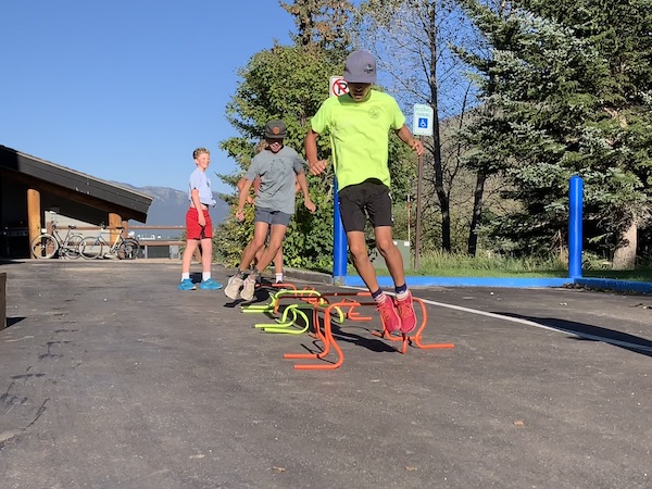 Three boys doing jump training down a line