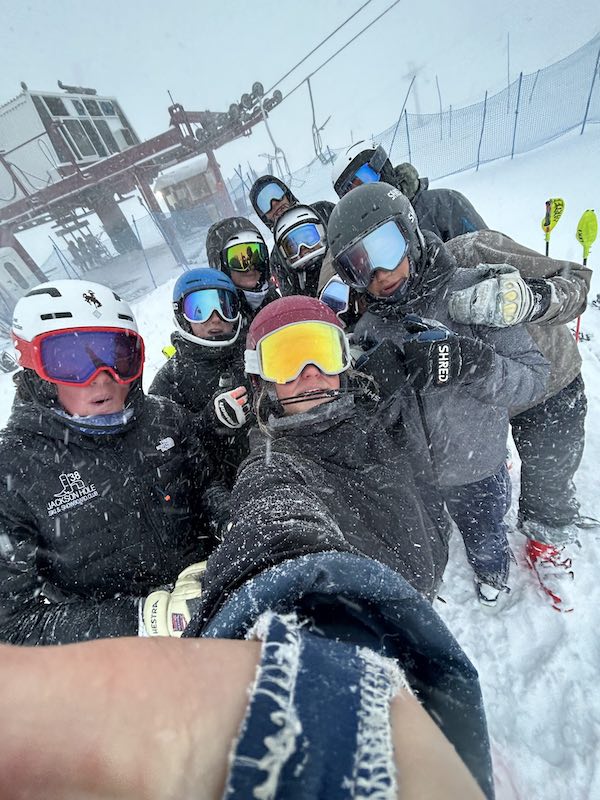 Group of skiers taking a selfie with goggles and helmets