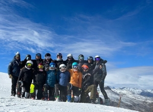 JHSC Alpine ski team taking a group photo on the snow